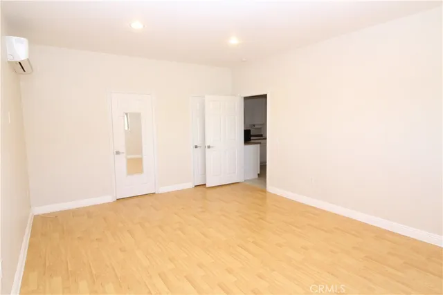 an empty room with wooden floor and closet