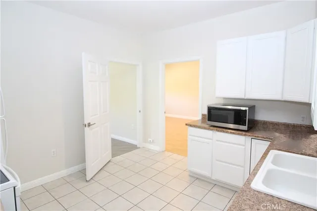 a kitchen with granite countertop white cabinets and white appliances
