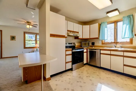 a kitchen with stainless steel appliances granite countertop a stove a sink and a refrigerator
