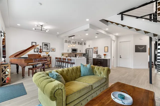 a living room with furniture ceiling fan and a wooden floor