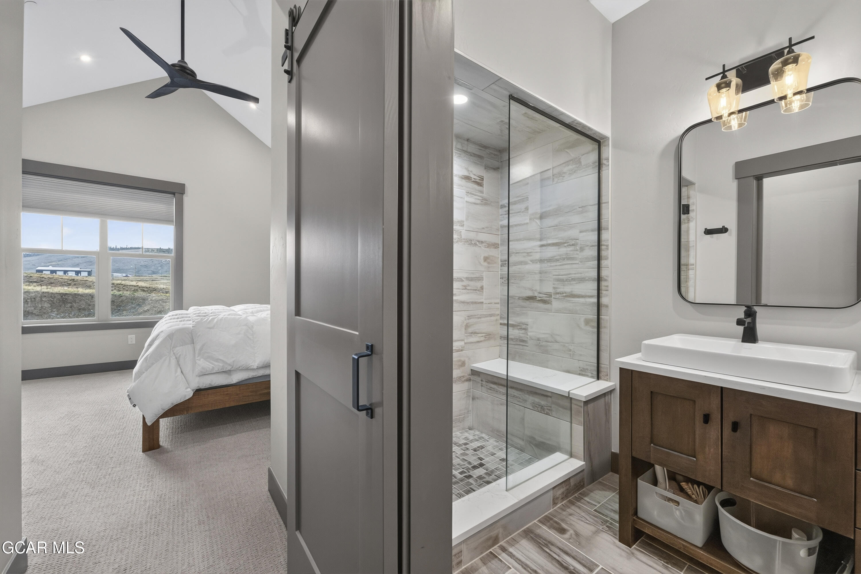 154 Eagle Ridge Drive Granby, CO 80446 - Photo 32 of 59 a en suite bathroom with a double vanity sink and a mirror