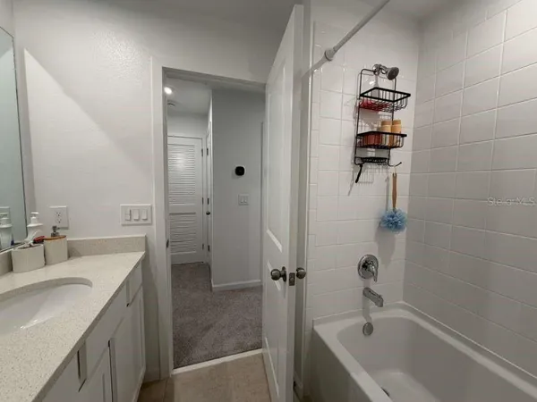 a bathroom with a tub sink and mirror