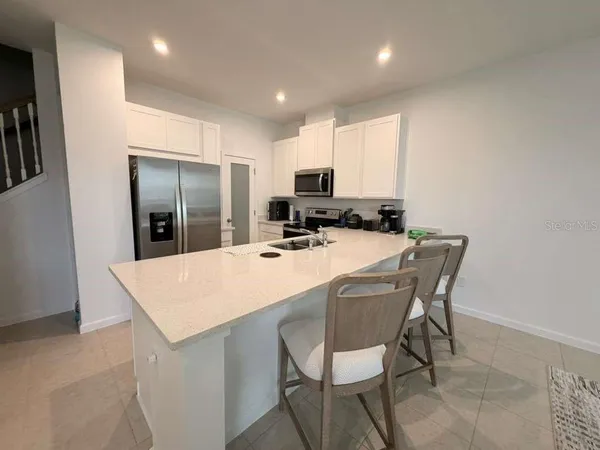 a kitchen with kitchen island a appliances dining table and chairs