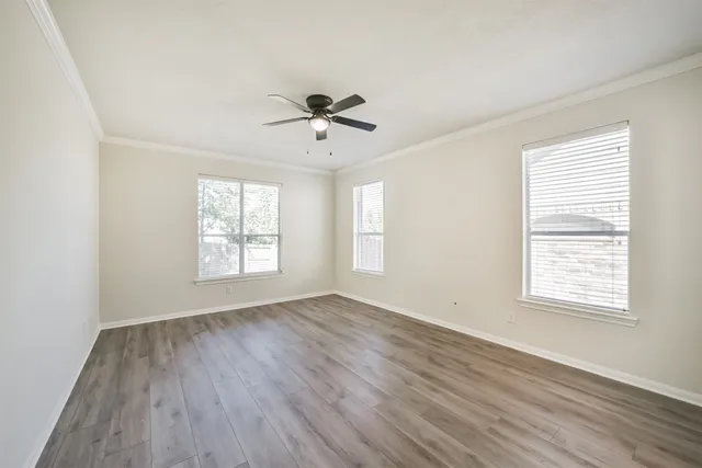 a view of a room with wooden floor and ceiling fan