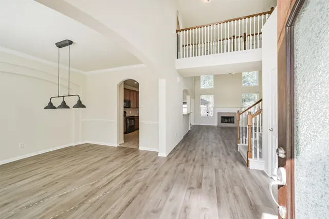 an empty room with windows a fireplace and wooden floor