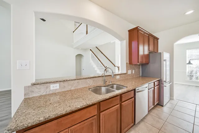 a kitchen with stainless steel appliances granite countertop a refrigerator sink and cabinets