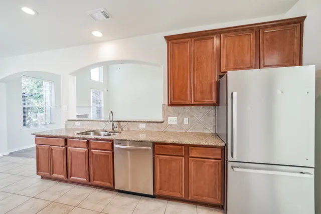a kitchen with stainless steel appliances granite countertop a stove top oven a sink dishwasher and a microwave oven on the blue kitchen countertops