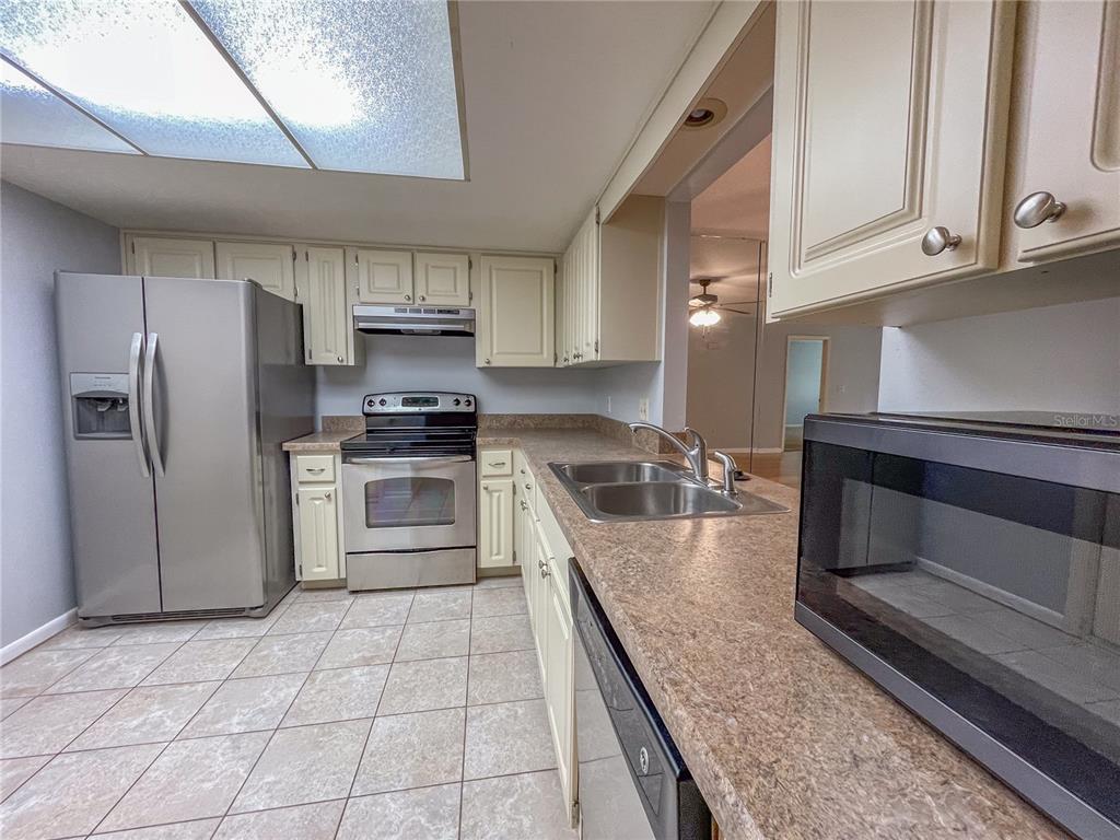 63 Douglas Street, Unit 11 Homosassa, FL 34446 - Photo 3 of 27 a kitchen with granite countertop a stove a microwave and refrigerator