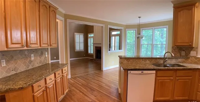 a kitchen with granite countertop wooden cabinets a granite counter top and a sink