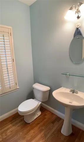 a bathroom with a toilet a sink and mirror