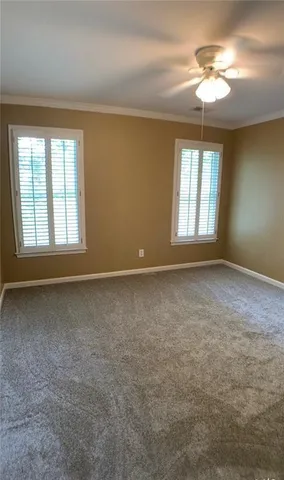 an empty room with a window and a ceiling fan