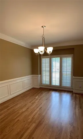 a view of wooden floor chandelier and window in a room
