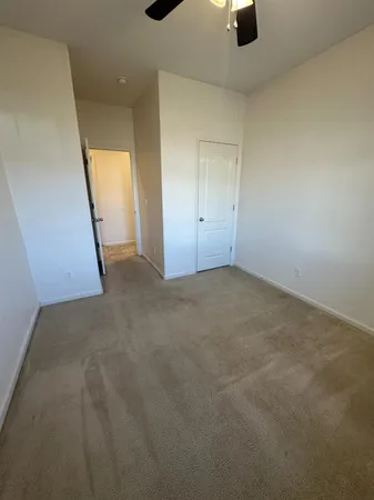 en empty room with windows and ceiling fan