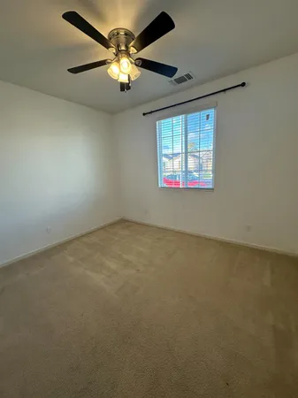 an empty room with a window and a fan
