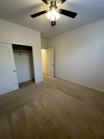 en empty room with windows and ceiling fan