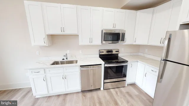 a kitchen with white cabinets and white appliances