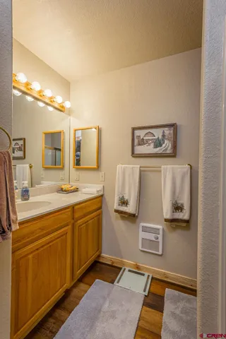 a spacious bathroom with a granite countertop sink and a mirror