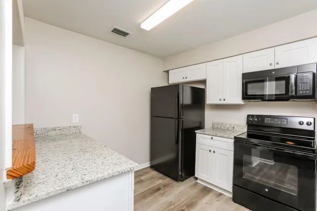 a kitchen with stainless steel appliances granite countertop a refrigerator stove and microwave