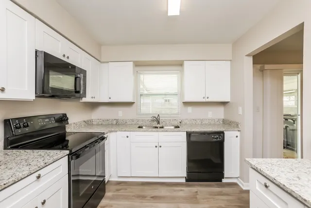 a kitchen with stainless steel appliances granite countertop a sink stove and microwave