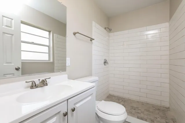 a bathroom with a sink a toilet and shower