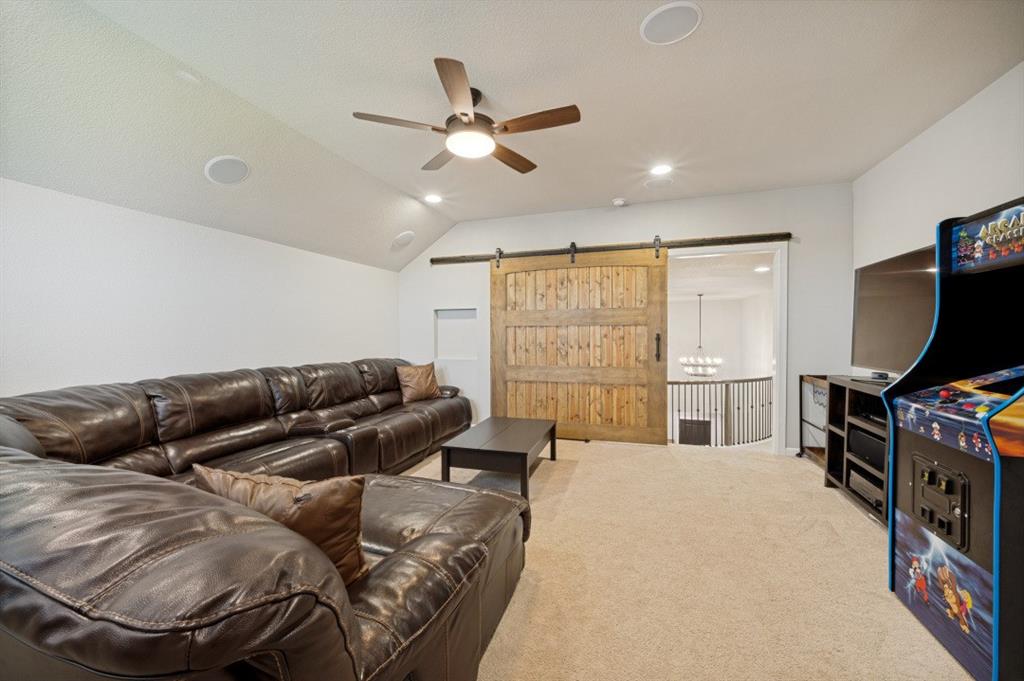 2721 Old Shire Path Road Prosper, TX 75078 - Photo 21 of 39 Spacious media/game room featuring a vaulted ceiling with a ceiling fan, recessed lighting, and built-in ceiling speakers