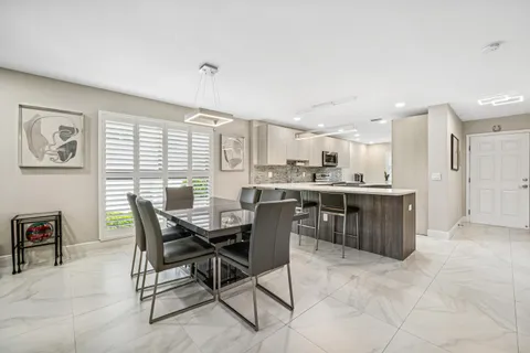 a dining area with a table chairs and a kitchen view