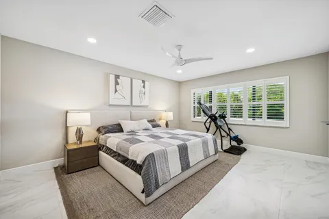 a spacious bedroom with a bed and a flat screen tv