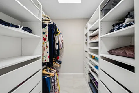 a spacious bedroom with a bed a dresser and a flat screen tv