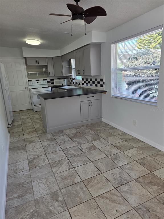 298 11th Avenue Southwest Largo, FL 33770 - Photo 26 of 34 a large kitchen with stainless steel appliances granite countertop a stove a sink and a refrigerator