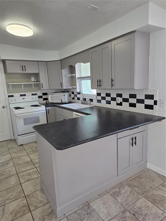 298 11th Avenue Southwest Largo, FL 33770 - Photo 10 of 34 a kitchen with stainless steel appliances granite countertop a sink stove and refrigerator