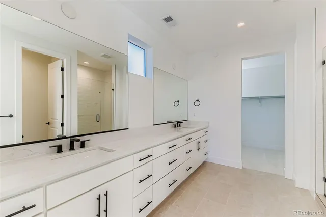 a bathroom with a double vanity sink and mirror