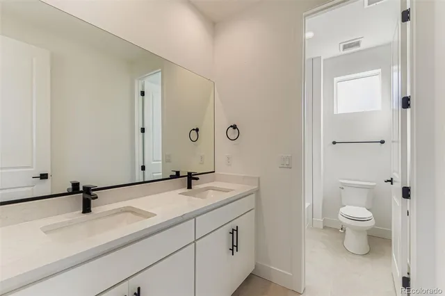 a bathroom with a sink a toilet and a mirror