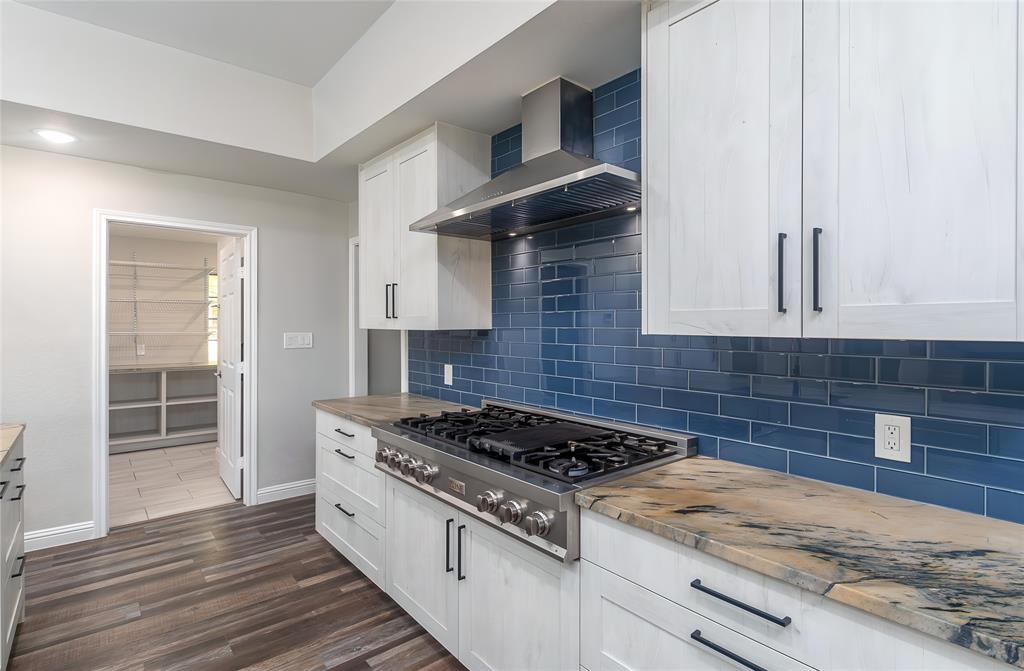13 Crestview Circle Rockwall, TX 75087 - Photo 15 of 37 a kitchen with granite countertop a stove and a wooden floors