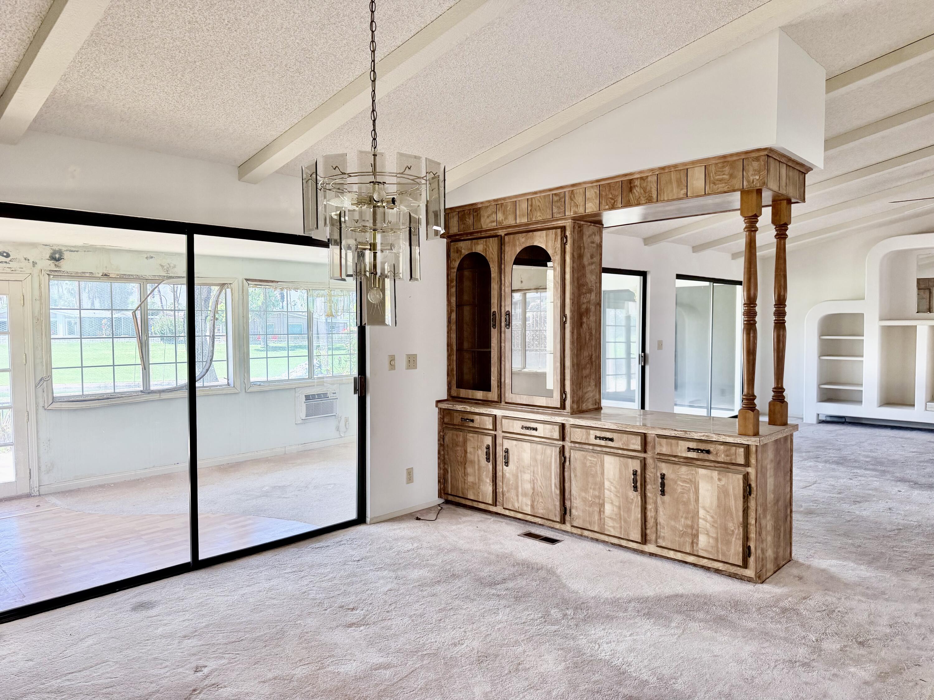 74361 Angel Camp Road Palm Desert, CA 92260 - Photo 7 of 12 a view of a kitchen with an empty room and chandelier