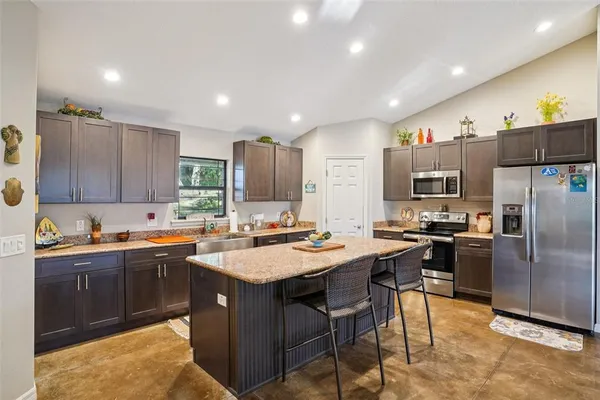 a dining room with wooden floor a chandelier a glass table and chairs
