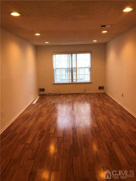 22 Prestwick Way, Unit 22 Edison, NJ 08820 - Photo 2 of 8 an empty room with wooden floor and windows