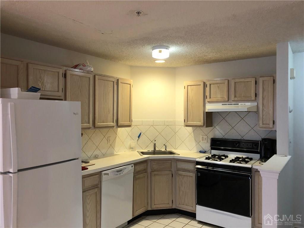 22 Prestwick Way, Unit 22 Edison, NJ 08820 - Photo 3 of 8 a white kitchen with sink and white stainless steel appliances