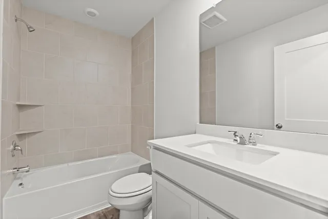 a bathroom with a granite countertop sink a toilet and a bathtub