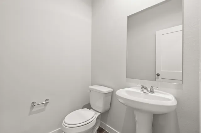 a bathroom with a sink toilet and a mirror