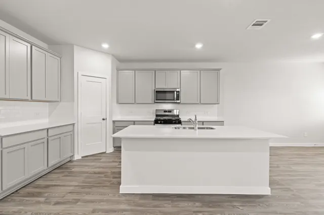 a kitchen with stainless steel appliances granite countertop a white stove top oven and white cabinets