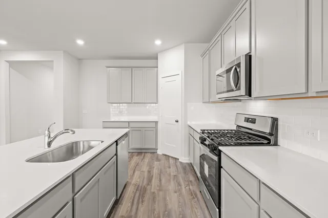 a kitchen that has a sink and a stove top oven