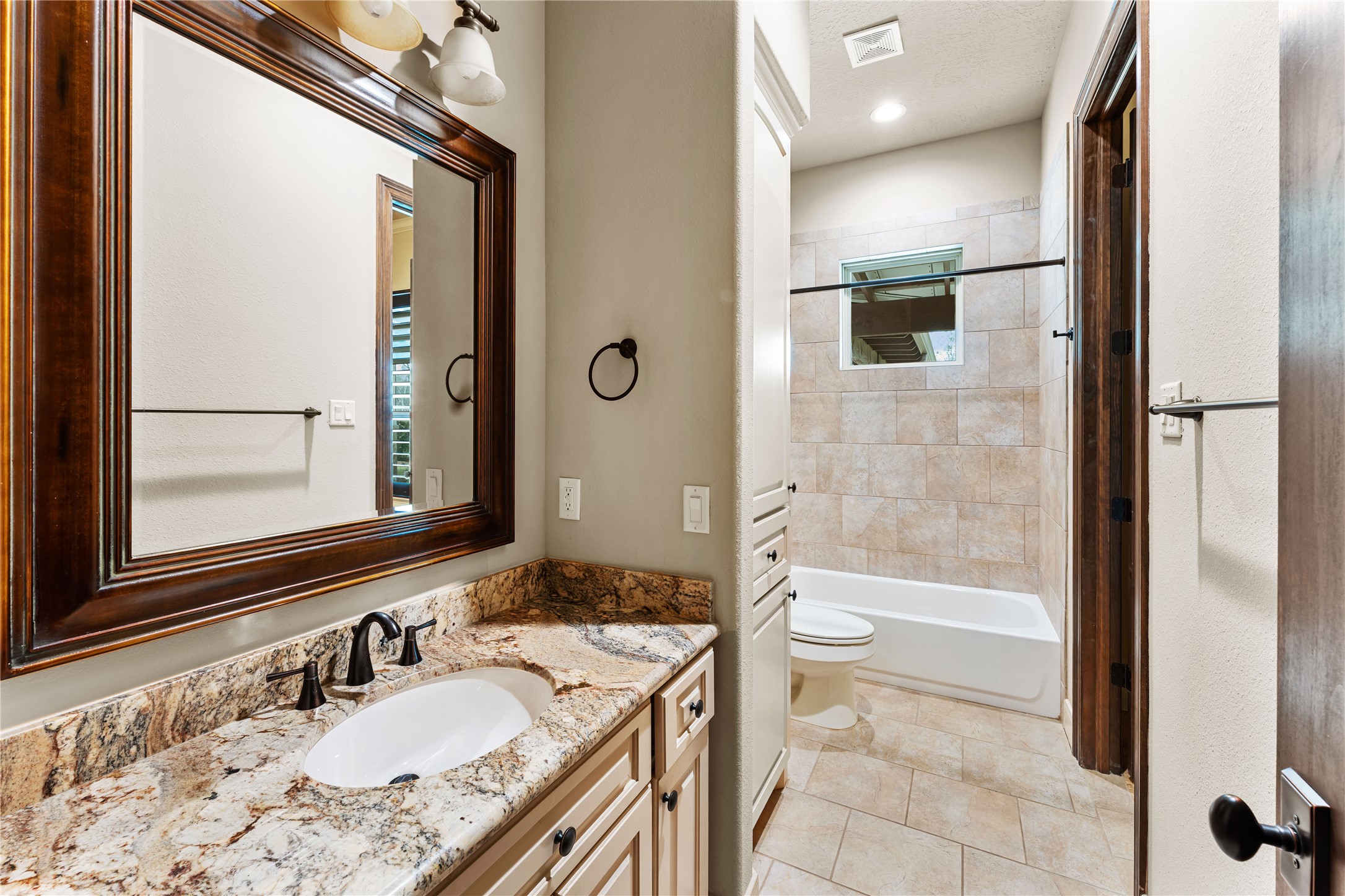 4727 Sugar Maple Court Fulshear, TX 77441 - Photo 31 of 50 a bathroom with a granite countertop sink a mirror and a bathtub