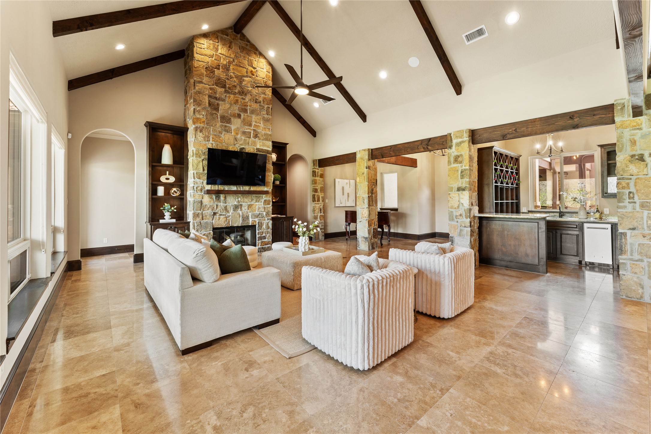 4727 Sugar Maple Court Fulshear, TX 77441 - Photo 6 of 50 The natural stone fireplace, columns and solid wood beams highlight the magnificent cathedral
ceiling in the living area. The wet bar is convenient to the living area and includes a wine cooler and
ice maker.