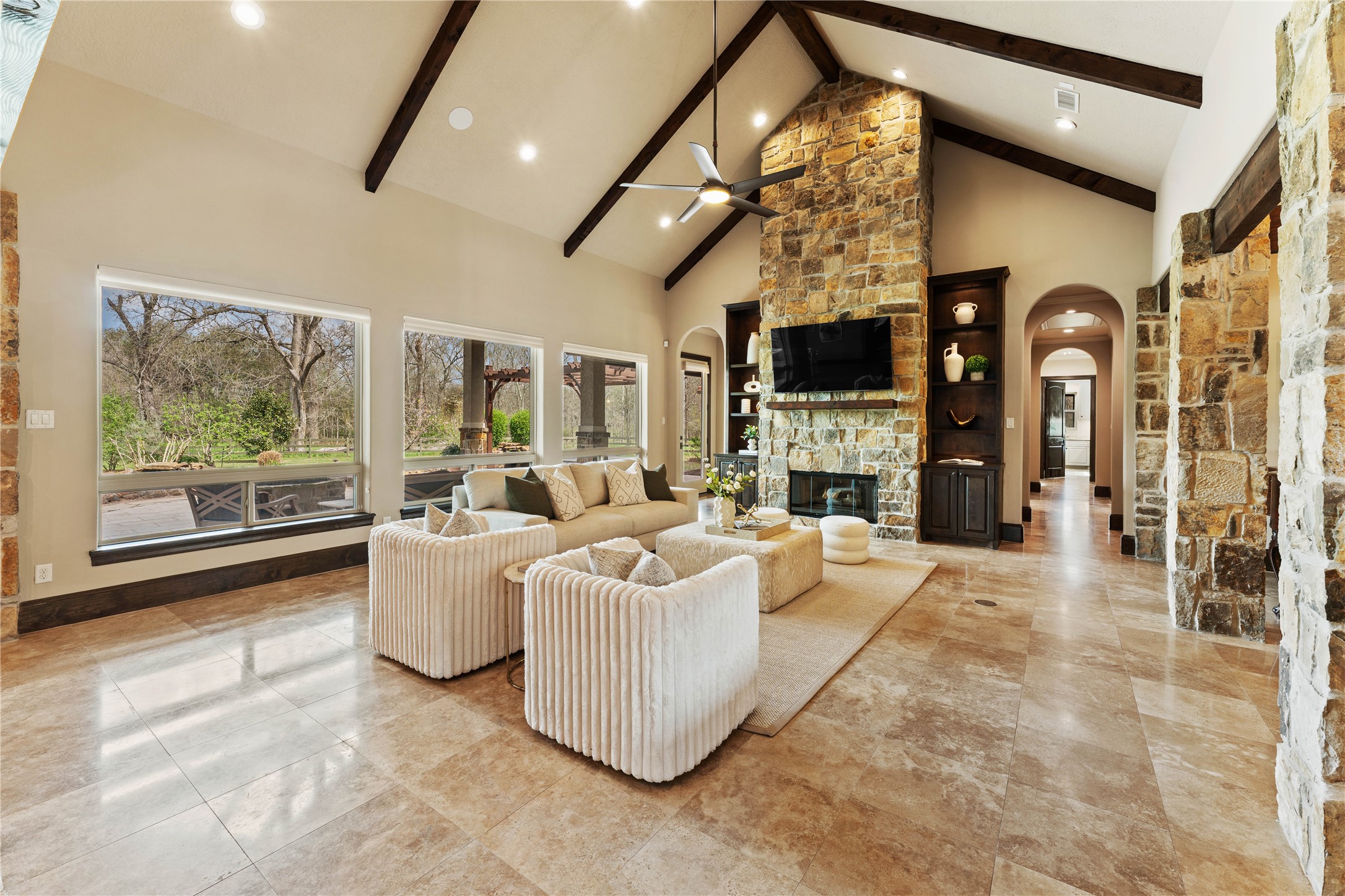 4727 Sugar Maple Court Fulshear, TX 77441 - Photo 7 of 50 Built-in cabinetry, travertine floors, arched doorways and a view of the serene outdoor living
area add to the appeal of the living room.