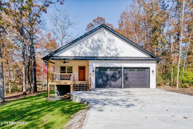 a view of a house with a big yard and large tree