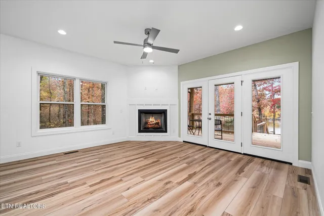 a view of an empty room with a fireplace and a window