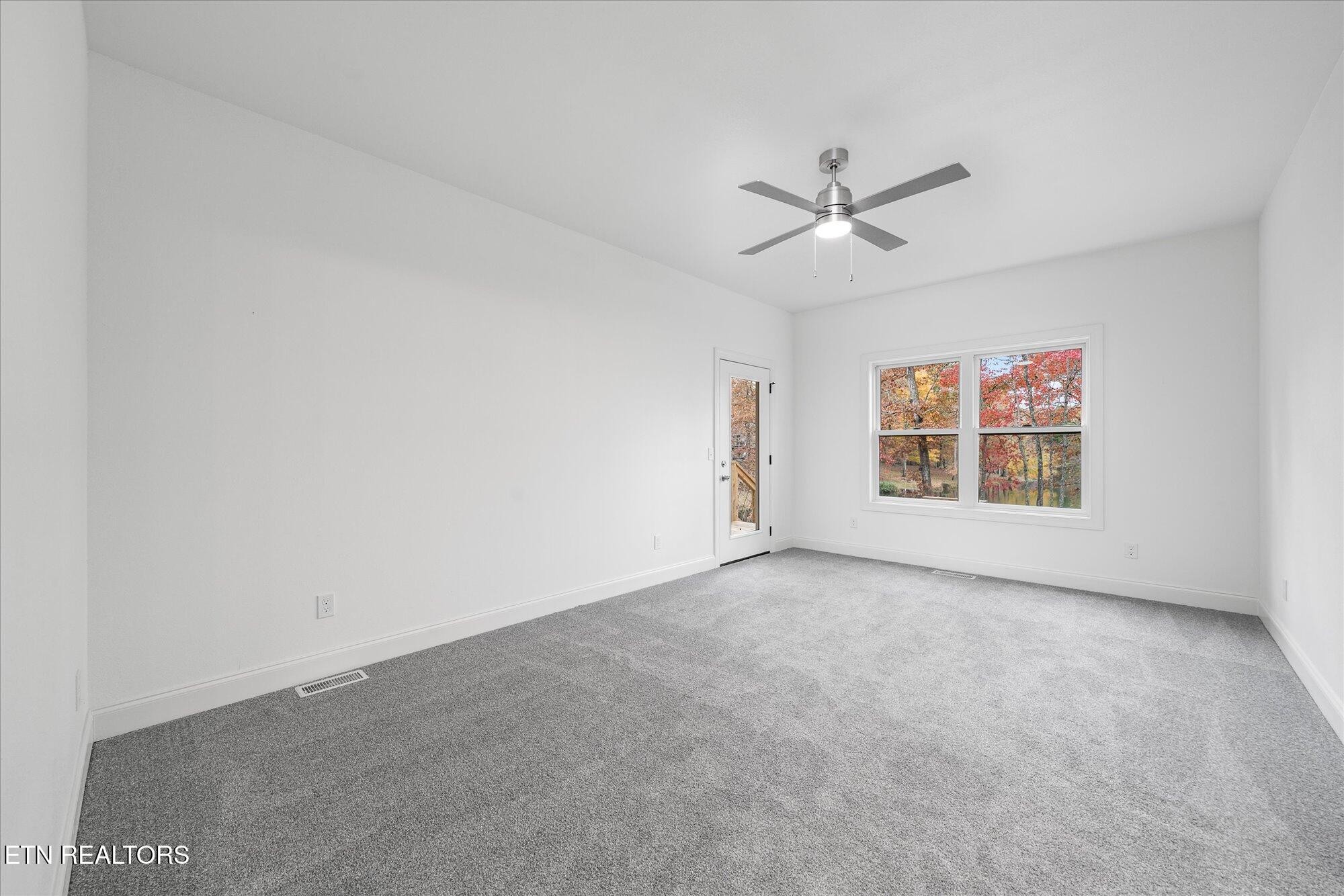 565 Grassland Road Crossville, TN 38572 - Photo 18 of 53 an empty room with windows and ceiling fan view