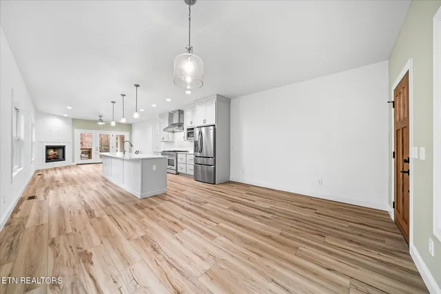 a kitchen with kitchen island white cabinets and stainless steel appliances