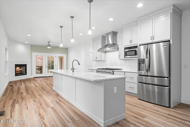 a kitchen with stainless steel appliances granite countertop a stove a sink and a white wooden cabinets