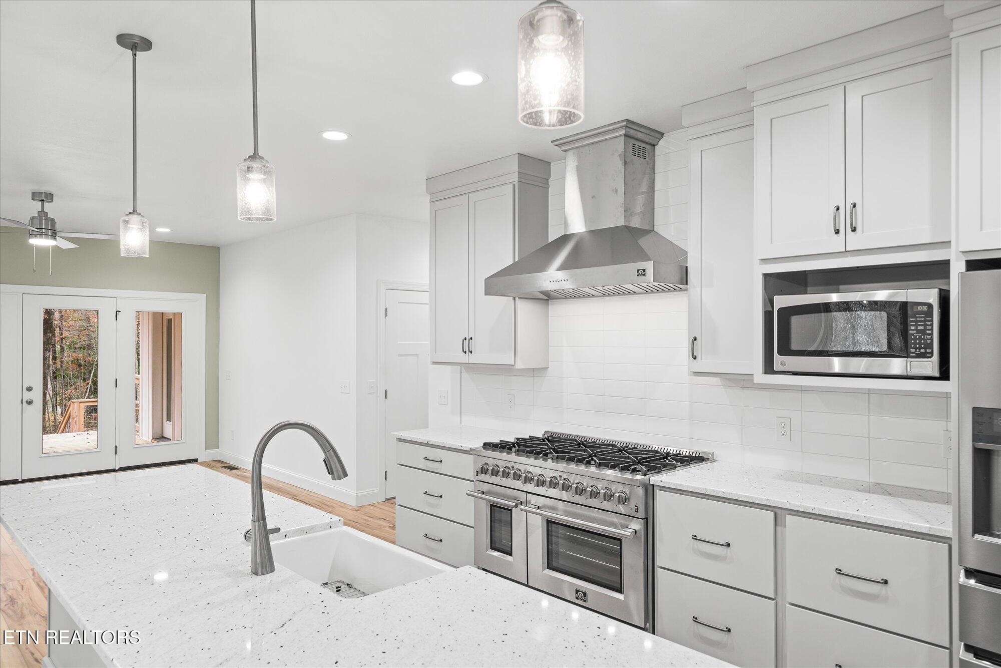 565 Grassland Road Crossville, TN 38572 - Photo 9 of 53 a kitchen with stainless steel appliances granite countertop a stove a sink and a white wooden cabinets